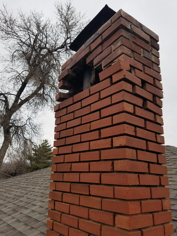 Red brick chimney with hole and brick damage