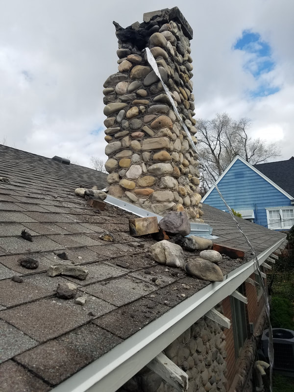 Rock Chimney with earthquake damage and rocks on roof by Utah Chimney